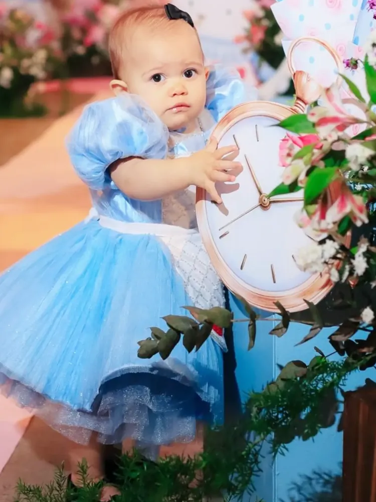 Bebê com vestido azul em festa tema Alice